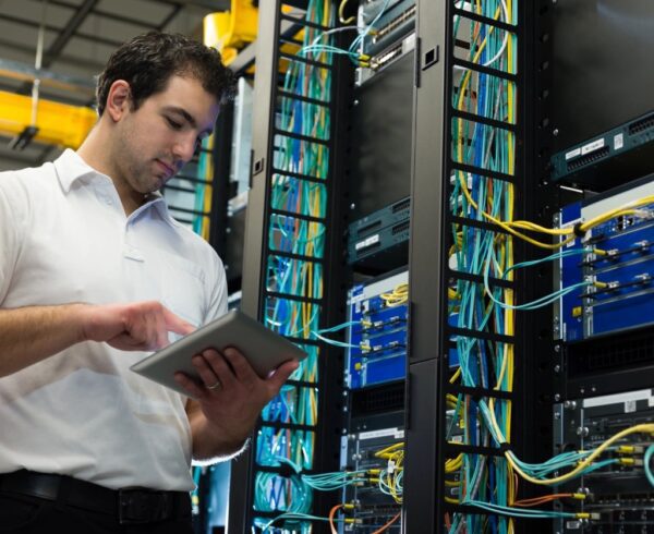 A picture of the man standing with the notepad in the data center